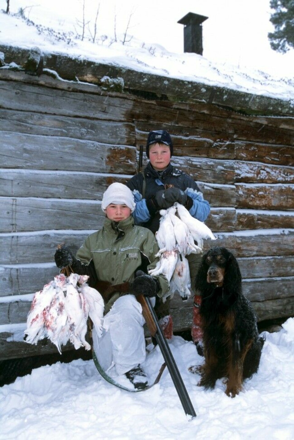 To stolte poder og en gammel gordon viser fram fedrenes fangst etter en vellykket vinterjakt. Slikt gir minner for livet.