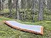 Utmark liggeunderlag, et lydløst og varmt underlag som er fint å ha med seg på tur. Her er liggeunderlaget avbildet i skogen.